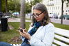 an older woman sitting on a bench using her cell phone